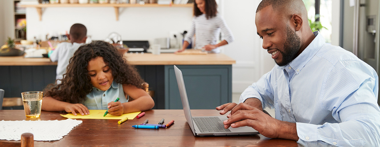 Family together in the kitchen with laptop computer